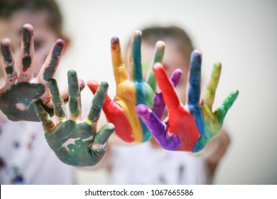 Two little girls with colored hands. Close up. Focus on hands.