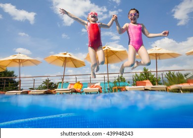 Two Little Girls Jumping In The Pool