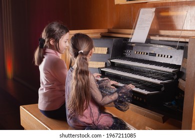 Two little girls play the organ in 4 hands - Powered by Shutterstock