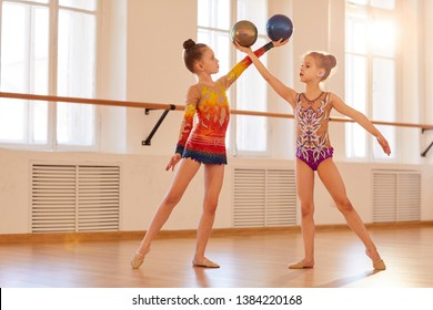 Two little girls practicing rhythmic gymnastics in class, copy space - Powered by Shutterstock