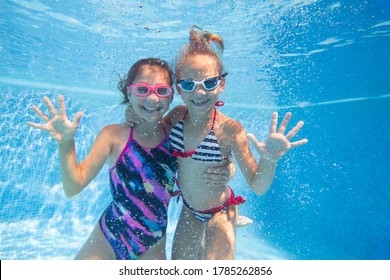 Two Little Girls Swimming In Pool. Under Water Photo,