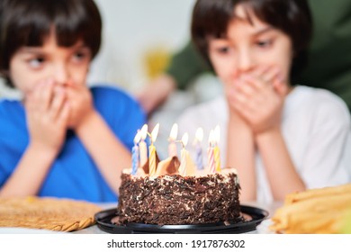 Two Little Hispanic Twins Looking At Birthday Cake, Making Wishes While Preparing For Blowing Candles. Latin Family Celebrating Birthday Together At Home