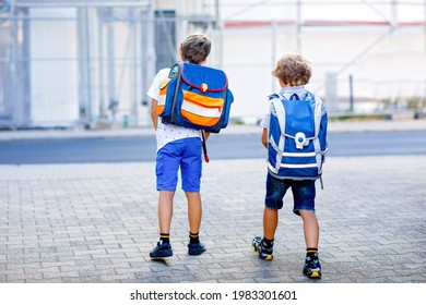 Two Little Kid Boys With Backpack Or Satchel. Schoolkids On The Way To School. Healthy Adorable Children, Brothers And Best Friends Outdoors On The Street Leaving Home. Back To School. Happy Siblings.