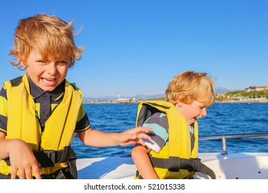 Two Little Kid Boys, Best Friends Enjoying Sailing Boat Trip. Family Vacations On Ocean Or Sea On Sunny Day. Children Smiling.