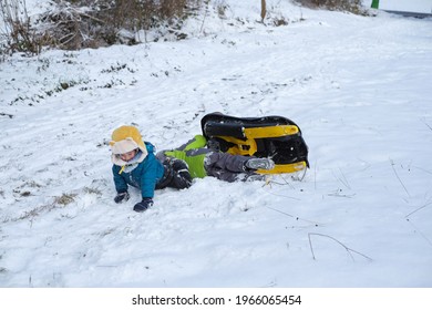 Two Little Kid Boys, Boy Brothers Playing Snow BOB Sled Having Fun In The Snowy Wintertime.