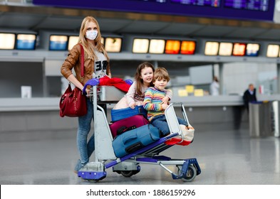 Two Little Kids, Boy And Girl And Mother In Medical Mask At Airport. Children, Family Travel By Plane During Corona Virus Pandemic Lockdown. People In Mask As Preventive Measure And Covid Protection