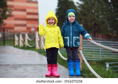 Two Little Kids, Boy And Girl, Watch Monkey Show In The Zoo On A Cold Autumn Day. Children Watching Animals In Safari Park.
