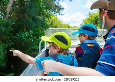 Two Little Kids Boys And Father Making Air Boat Tour In Florida Wetland Swamp At Everglades National Park In USA. Family, Dad And Children Discovering Wild Nature And Animals. Family Having Fun.