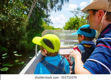 Two Little Kids Boys And Father Making Air Boat Tour In Florida Wetland Swamp At Everglades National Park In USA. Family, Dad And Children Discovering Wild Nature And Animals. Family Having Fun.