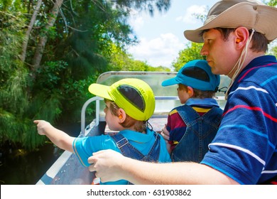 Two Little Kids Boys And Father Making Air Boat Tour In Florida Wetland Swamp At Everglades National Park In USA. Family, Dad And Children Discovering Wild Nature And Animals. Family Having Fun.