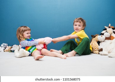 Two Little Kids, Brother And Sister Fighting Over A Toy. The Conflict Between Children.

