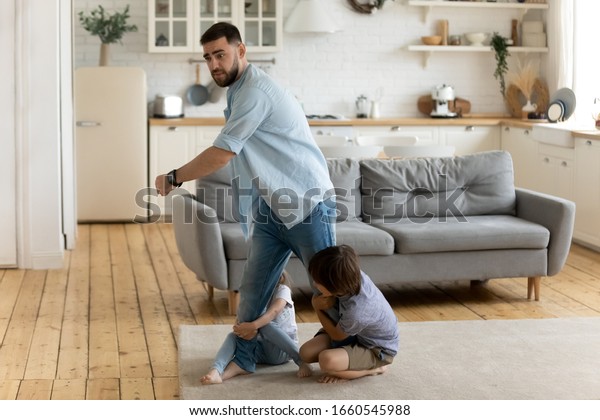 Two little kids brother and sister hold young\
father not letting go show affection bonding, small children\
siblings attached to dad, undergo parents divorce, suffer from\
psychological family drama