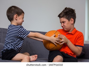 Two little kids, brothers fighting over a toy. the conflict between children over a ball