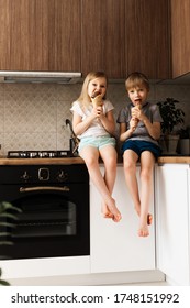 Two Little Kids Eating Ice Cream In Kitchen At Home, Smiling And Enjoying, Lifestyle, Vertical