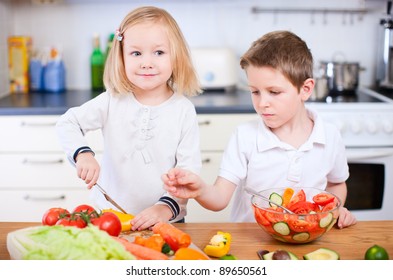 Two Little Kids Helping At Kitchen With Salad Making