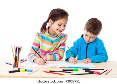 Two Little Kids At The Table Draw With Crayons, Isolated On White