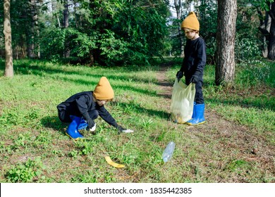 Two Little Kids Taking Care Of Nature Ecology And Picking Garbage In Plastic Bags Cleaning Ground. Kids Cleaning Up Litter On Grass, Feel Active While Volunteering, Gather Rubbish Outdoor, Gathering L