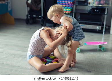 Two Little Siblings Children Quarrelling After Playing At Room At House. Crying Offended Toddler Boy Arguing With Elder Sister. Family Rivalry And Generation Conflict Concept