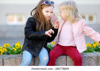 Two Little Sisters Fighting Outdoors