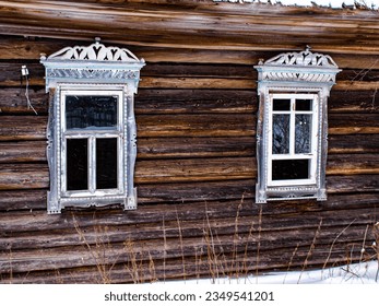 Two lonely broken windows. Alienation of abandoned villages. Amazing beautiful platbands with mushrooms made of wood.