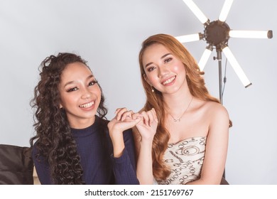Two lovely asian ladies making a pinky swear. Making a lighthearted pact. 2 models on location at a photographic studio. - Shutterstock ID 2151769767