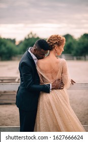 Two Lovers Man And Woman Stand Embracing On A Ranch At Sunset, Man Kisses Woman Neck