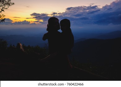 Two Lovers Mother And Son In Silhouette At Sunset Background.