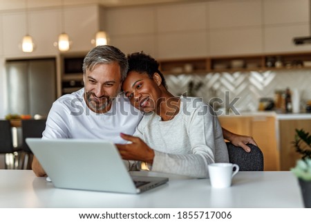 Two lovers watching old photos from laptop.