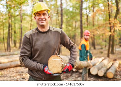 Two lumberjacks or forest workers carry a log during the harvest - Powered by Shutterstock