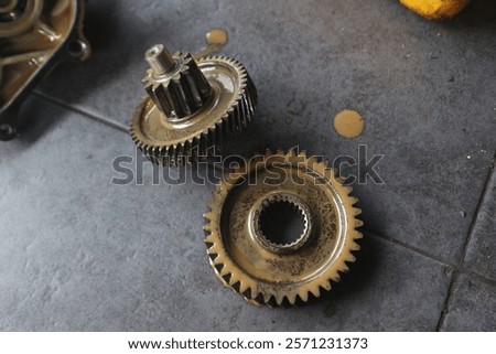 Two machine gears of different sizes, looking dirty and oily