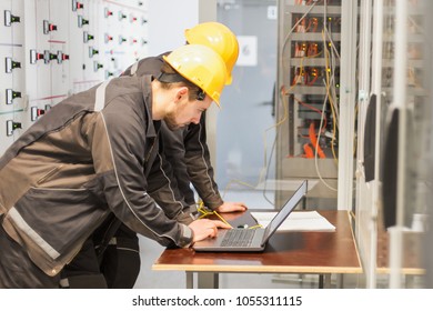 Two maintenance engineers inspect relay protection system with laptop computer. Bay control unit. Medium voltage switchgear - Shutterstock ID 1055311115