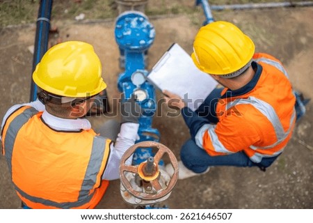 Two maintenance workers are checking water meters and inspecting the condition of water taps and valves