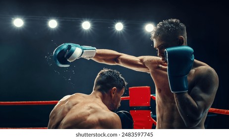 Two Male Boxers in an Electrifying Match, One Delivering Powerful Punch Under Bright Lights. Intensity and Raw Energy of the Fight Are Captured, With Sweat Flying Off Their Bodies. Boxing Championship - Powered by Shutterstock