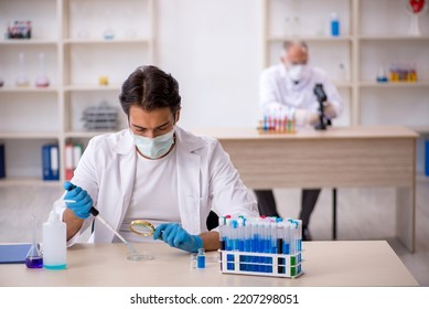 Two Male Chemist Working At The Lab