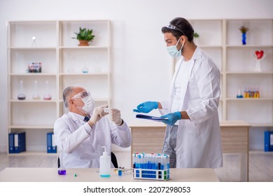 Two Male Chemist Working At The Lab