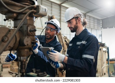 Two male engineers in uniform with helmet checking and repairing drilling machines at factory Industrial.Preventive Maintenance concept - Powered by Shutterstock