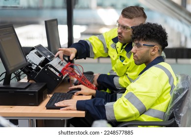 Two male engineers using desktop computer training Programmable logic controller or Programmable controller in the manufacturing automation and robotics academy room. Industrial computer concept - Shutterstock ID 2248577885