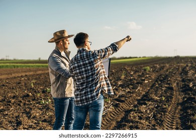 two male farmers talking on field - Powered by Shutterstock