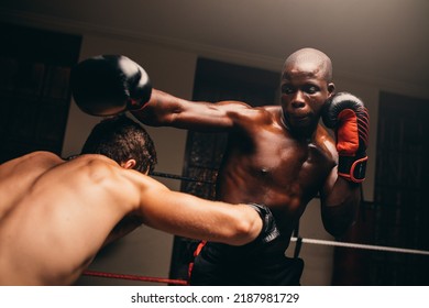 Two male fighters having a match in a boxing ring. Two young boxers throwing punches at each other in a gym. - Powered by Shutterstock