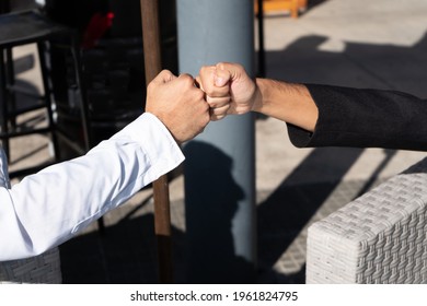 Two Male Friends Greeting Each Other With Fists Bumping. Close Up.