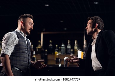 Two Male Friends Meet At The Bar At The Counter And Communicate.