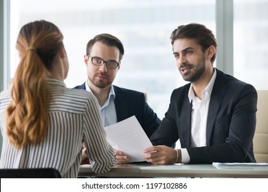 Two Male Hr Managers At Interview With Female Applicant. Man With Resume In Hands Asks Questions To Candidate. Hiring, Staff Recruiting Process.