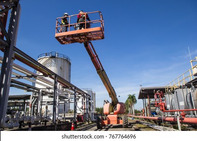 Two Male  Industry Working At High In A Boom Lift  Inspection Of Pipeline Oil