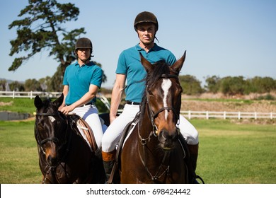 Two male jockeys riding horse in the ranch on a sunny day - Powered by Shutterstock