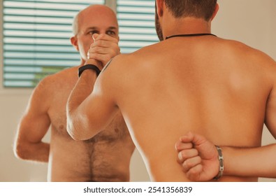 Two male martial arts practitioners are practicing a grappling technique, with one man holding the other's arm behind his back - Powered by Shutterstock