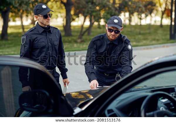 Two male police\
officers arrest a suspect