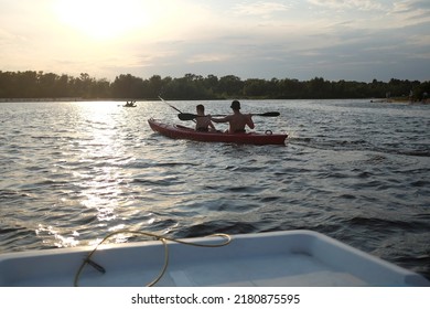 Two Male Rowers Swim In A Kayak On A Pond