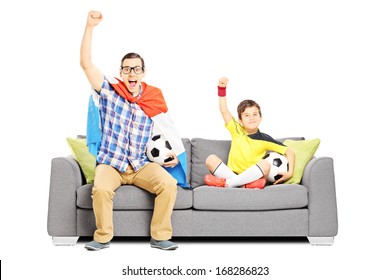 Two Male Sport Fans Seated On A Sofa Watching Sport Isolated On White Background