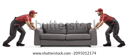 Two male workers moving a grey sofa isolated on white background