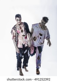 Two Male Zombies Standing On Black Background Walking Towards Camera